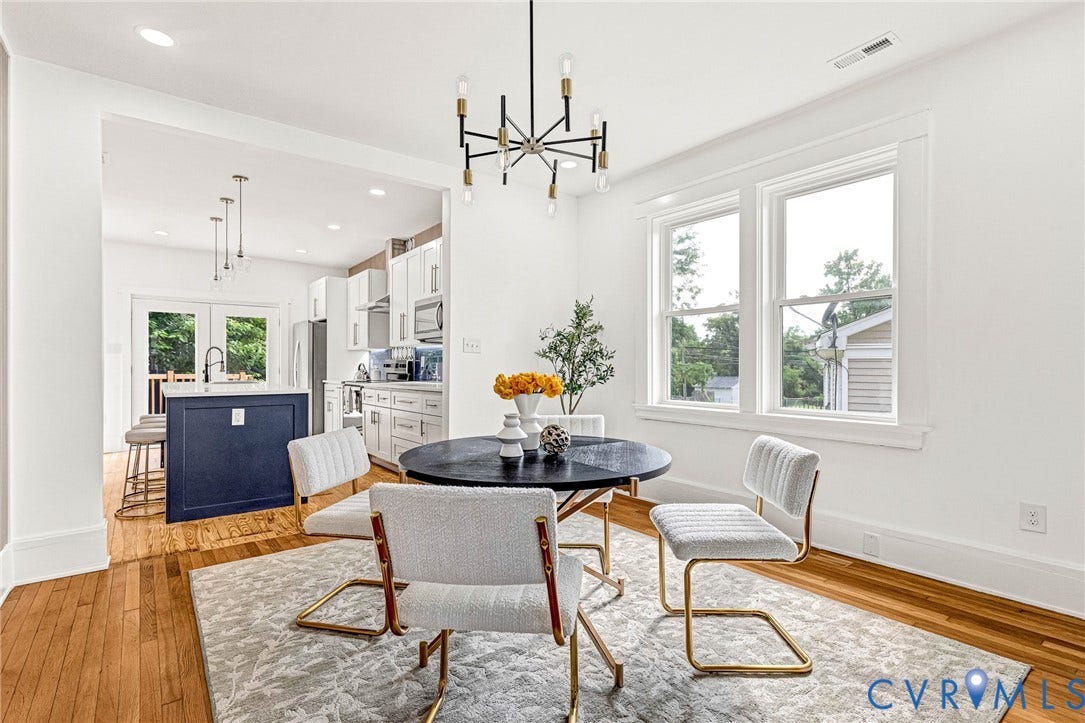 503 Pollock Street, Richmond, VA 23222 Hardwood flooring, crisp white walls, and an open archway leading to a kitchen with white cabinetry and a dark blue island