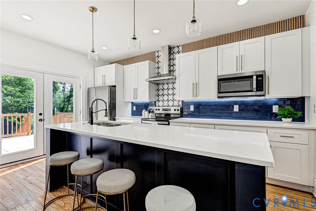 503 Pollock Street, Richmond, VA 23222 Gourmet kitchen featuring a large central island with white countertop, stainless steel appliances, white cabinetry, and a blue tile backsplash