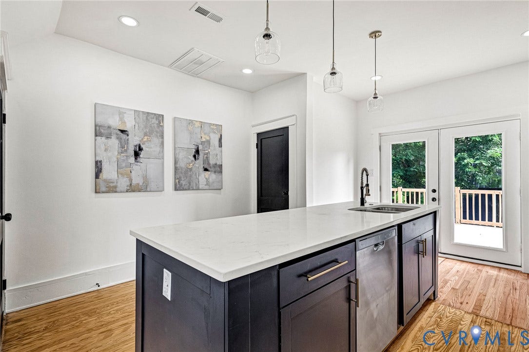 503 Pollock Street, Richmond, VA 23222 Kitchen island with a white countertop and integrated sink, stainless steel dishwasher, wood-finish flooring, recessed lighting, and double glass-paneled doors leading to an outdoor deck