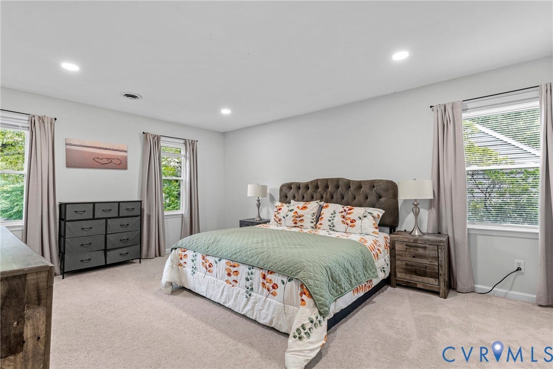 Neutral wall paint, recessed lighting, carpet flooring, and multiple windows