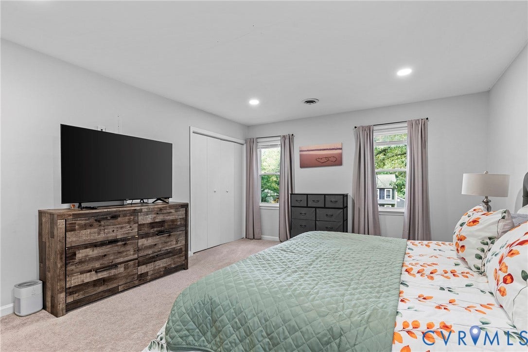 Recessed lighting, two windows with curtains, and a built-in closet with bi-fold doors