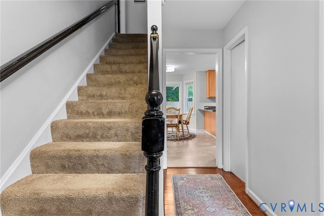 Staircase featuring carpeted treads and a dark wood newel post