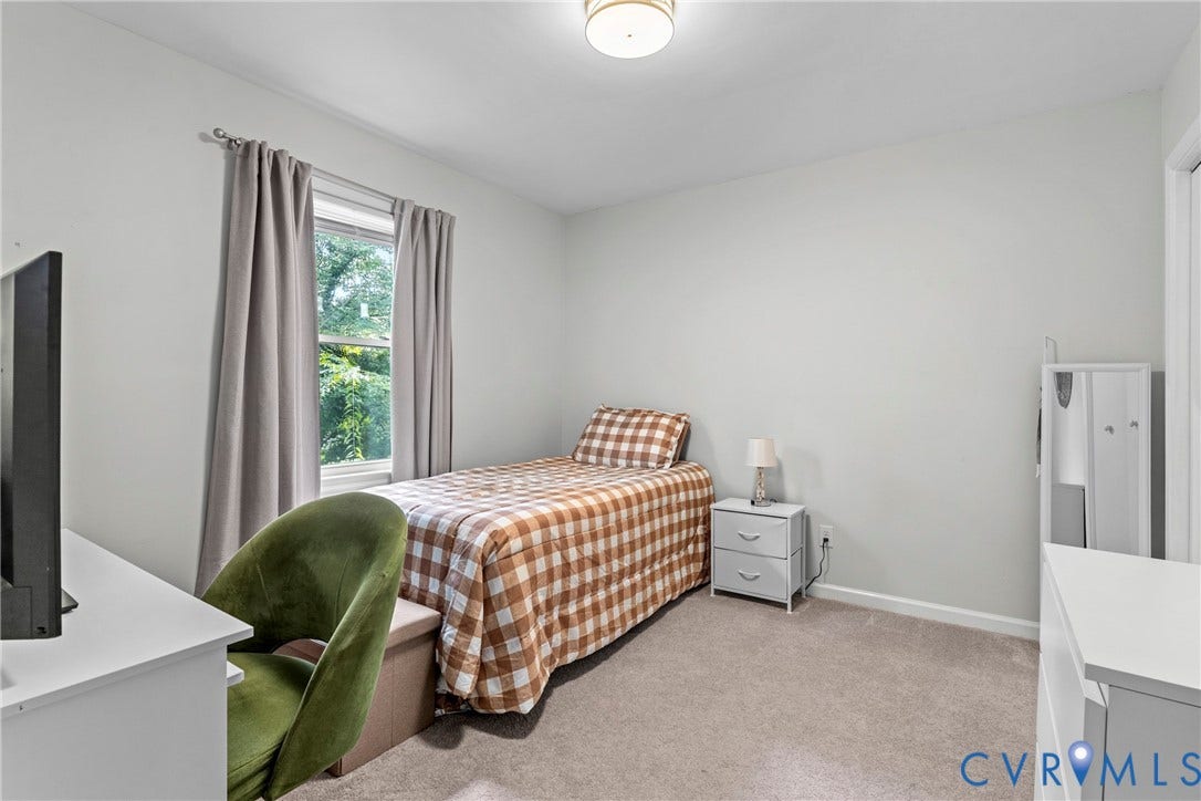 Recessed window with drapes, neutral wall color, and carpeted flooring