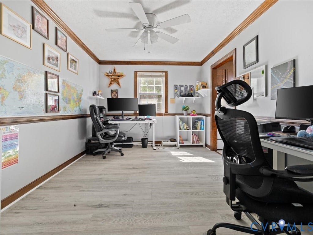 Spacious room featuring wood-finish flooring, a ceiling fan, and prominent window with natural light