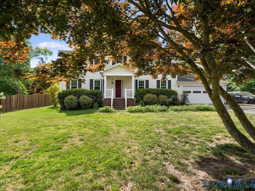 Traditional-style exterior with white siding, black shutters, and a red front door