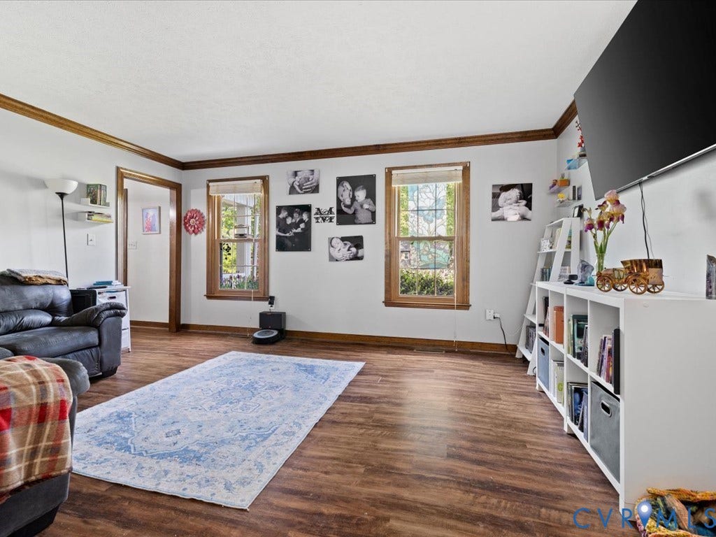 Wood-finish flooring throughout, light neutral wall paint, and natural wood trim accents