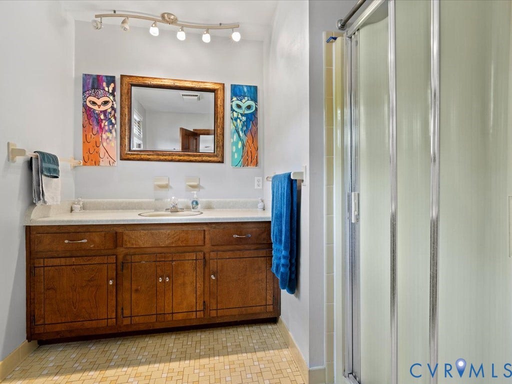 Double vanity with wood cabinetry and a light-toned countertop