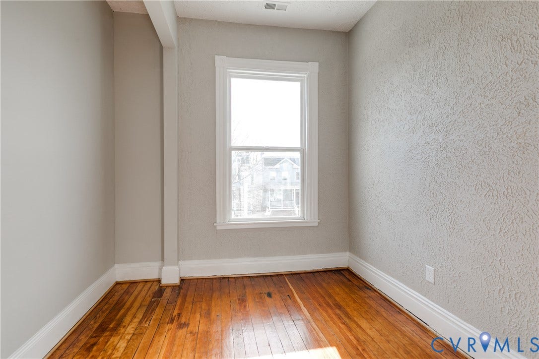 704 Chimborazo Boulevard, Chimborazo, Richmond, VA 23223 Hardwood flooring, white window trim, textured wall finish, painted baseboards, and a single window