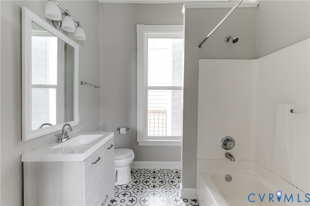 704 Chimborazo Boulevard, Chimborazo, Richmond, VA 23223 Bathroom featuring a single window, a vanity with integrated sink, chrome fixtures, a shower/tub combination, and patterned floor tiling