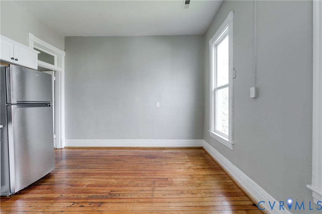 704 Chimborazo Boulevard, Chimborazo, Richmond, VA 23223 Hardwood flooring, stainless steel refrigerator, white cabinetry, white trim, and a double-hung window