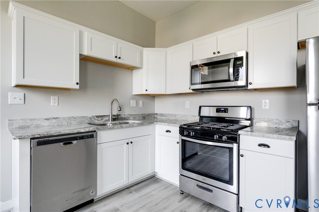 704 Chimborazo Boulevard, Chimborazo, Richmond, VA 23223 White shaker-style cabinetry with dark hardware, stainless steel appliances, light gray countertops, and wood-finish flooring