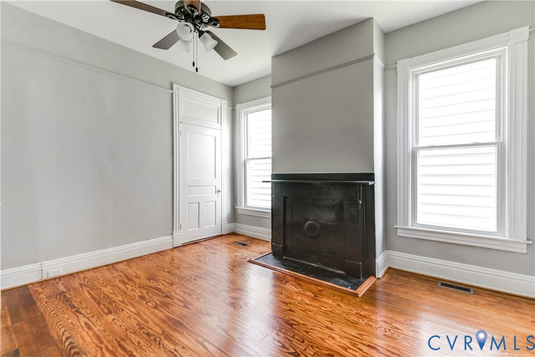 704 Chimborazo Boulevard, Chimborazo, Richmond, VA 23223 Hardwood flooring, decorative fireplace, multiple windows, classic paneled door, and a ceiling fan