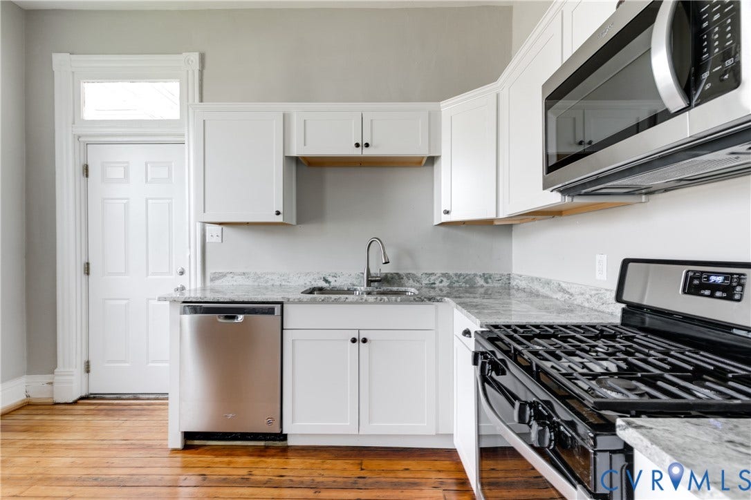 704 Chimborazo Boulevard, Chimborazo, Richmond, VA 23223 Kitchen featuring white shaker-style cabinetry, stainless steel appliances, a gas range, a built-in microwave, and stone countertops