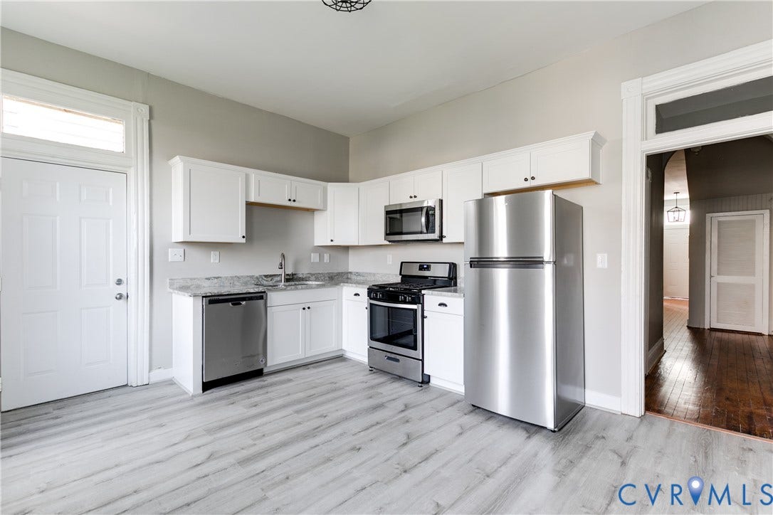 704 Chimborazo Boulevard, Chimborazo, Richmond, VA 23223 Kitchen featuring white cabinetry, stainless steel appliances, grey marble-look countertops, and wood-finish flooring