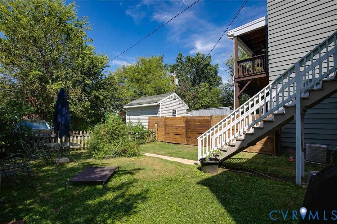 704 Chimborazo Boulevard, Chimborazo, Richmond, VA 23223 Grassed yard with a two-story exterior staircase and a second-story wooden balcony