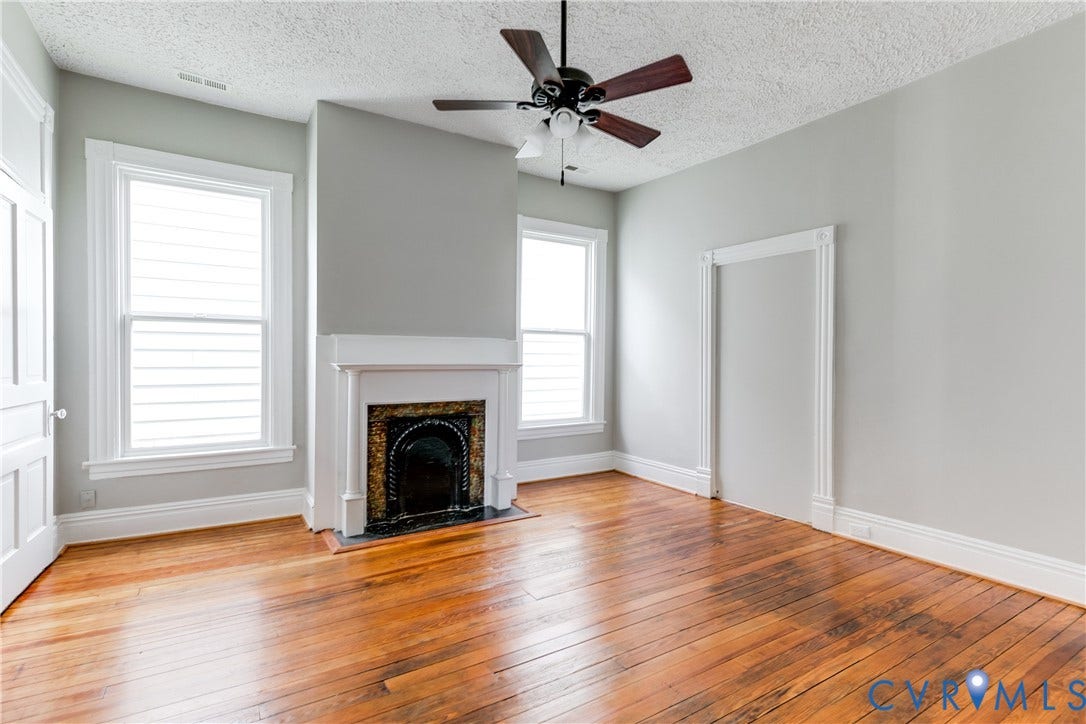 704 Chimborazo Boulevard, Chimborazo, Richmond, VA 23223 Hardwood flooring, decorative fireplace, multiple windows, ceiling fan, and white trim