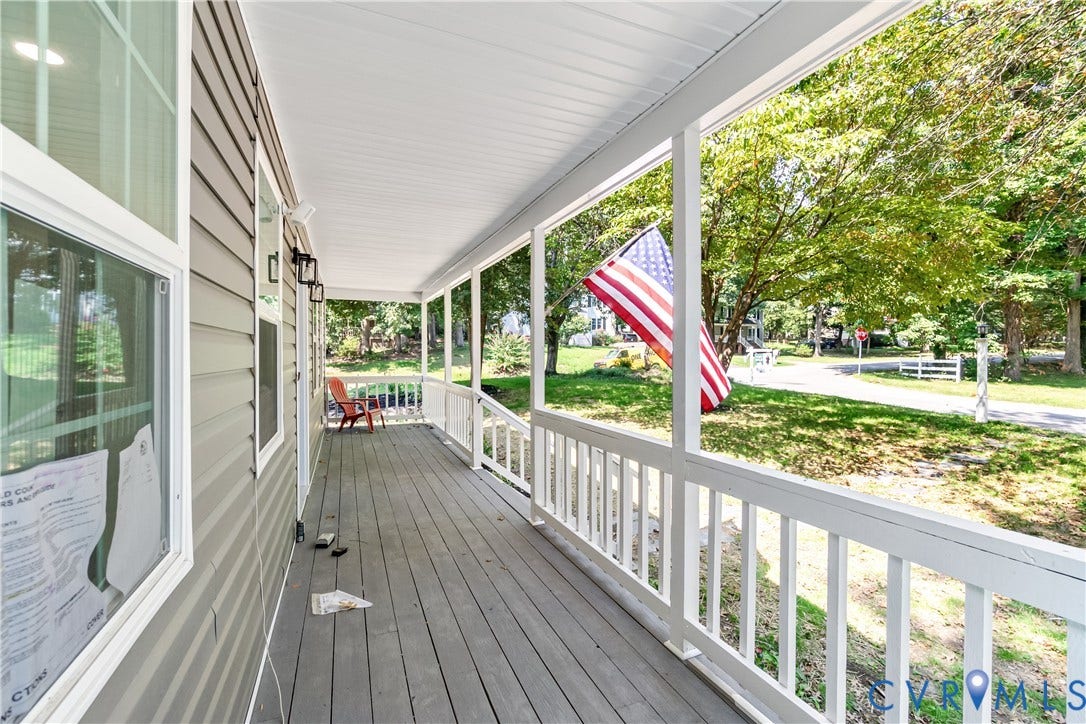 Expansive covered porch featuring a wood-finish floor, white railings, and a siding exterior