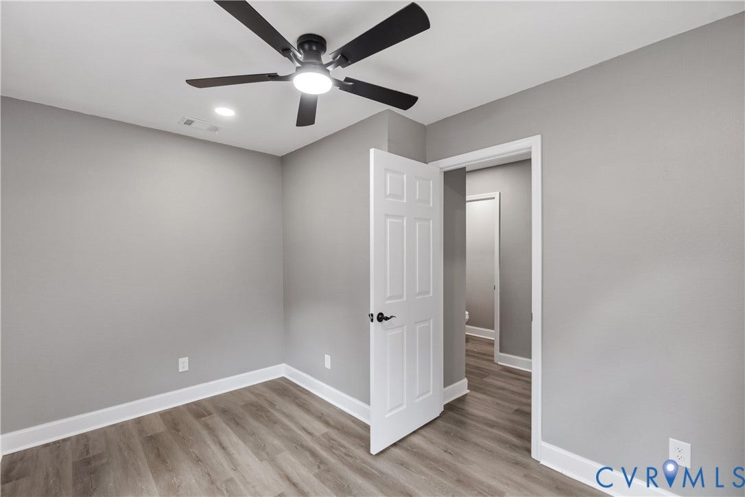 Neutral wall paint, wood-finish flooring, ceiling fan with integrated lighting, recessed lighting, and white trim throughout