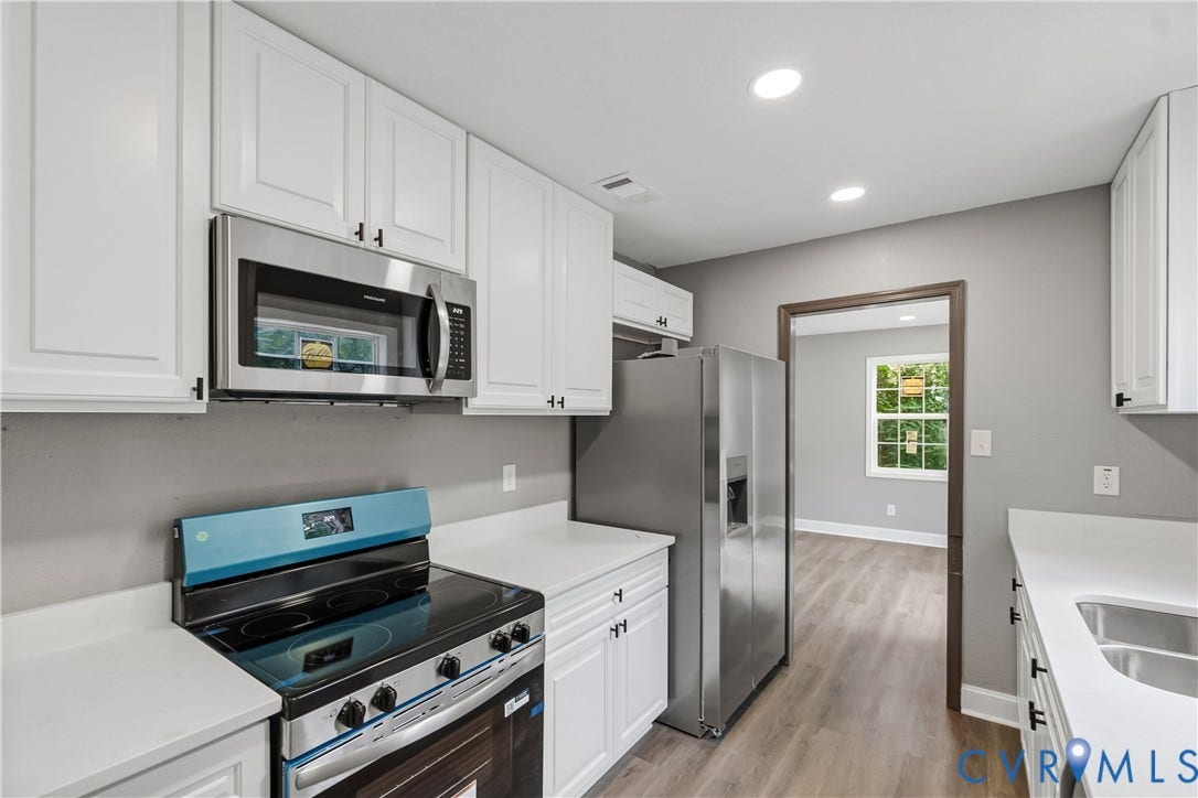 Kitchen featuring white cabinetry, stainless steel appliances, recessed lighting, wood-finish flooring, and light-toned countertops