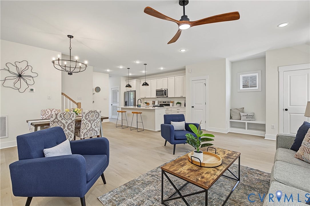 Open-concept living area with wood-finish flooring, a contemporary ceiling fan, and recessed lighting