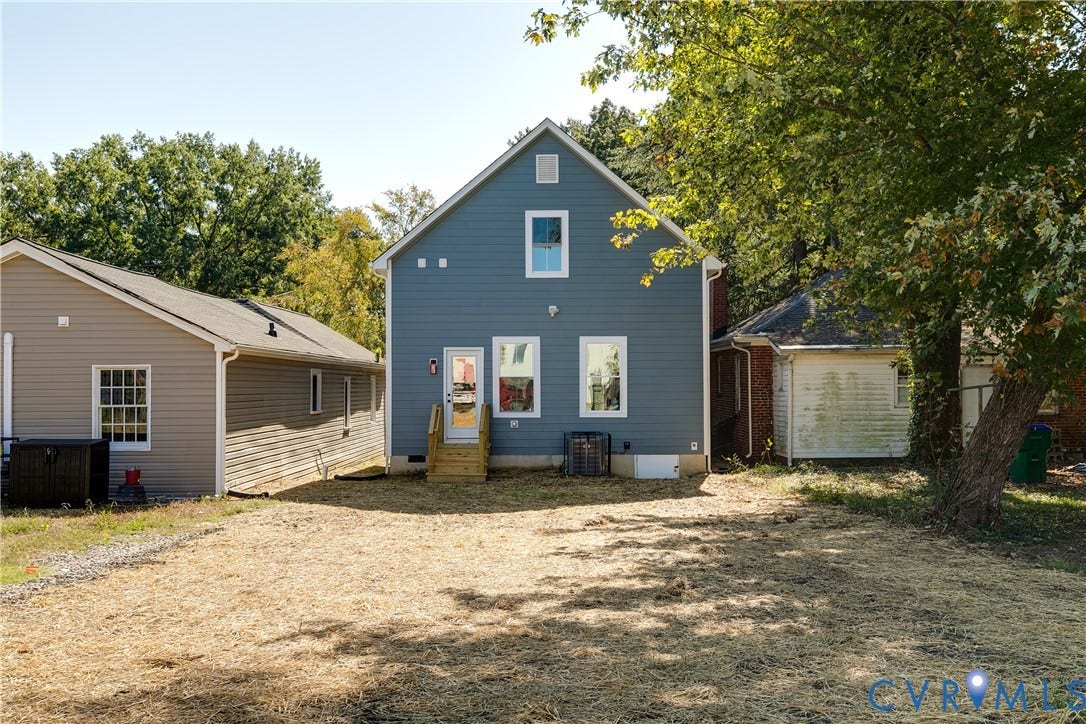 Blue siding exterior with white trim, featuring a rear entry door with new wooden steps