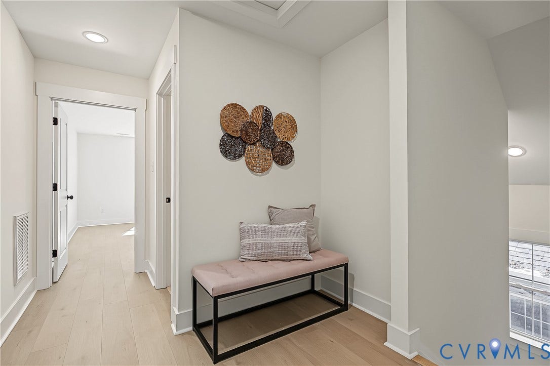 Wood-finish flooring throughout, recessed lighting, and white paneled doors with black hardware