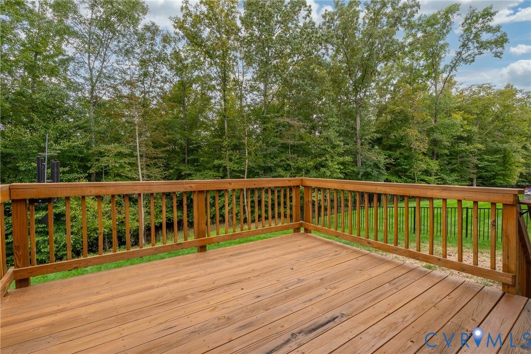 12303 Beech Hall Circle, Manakin Sabot, VA 23103 Expansive wood deck with a natural finish, featuring a surrounding wood railing and mature trees beyond