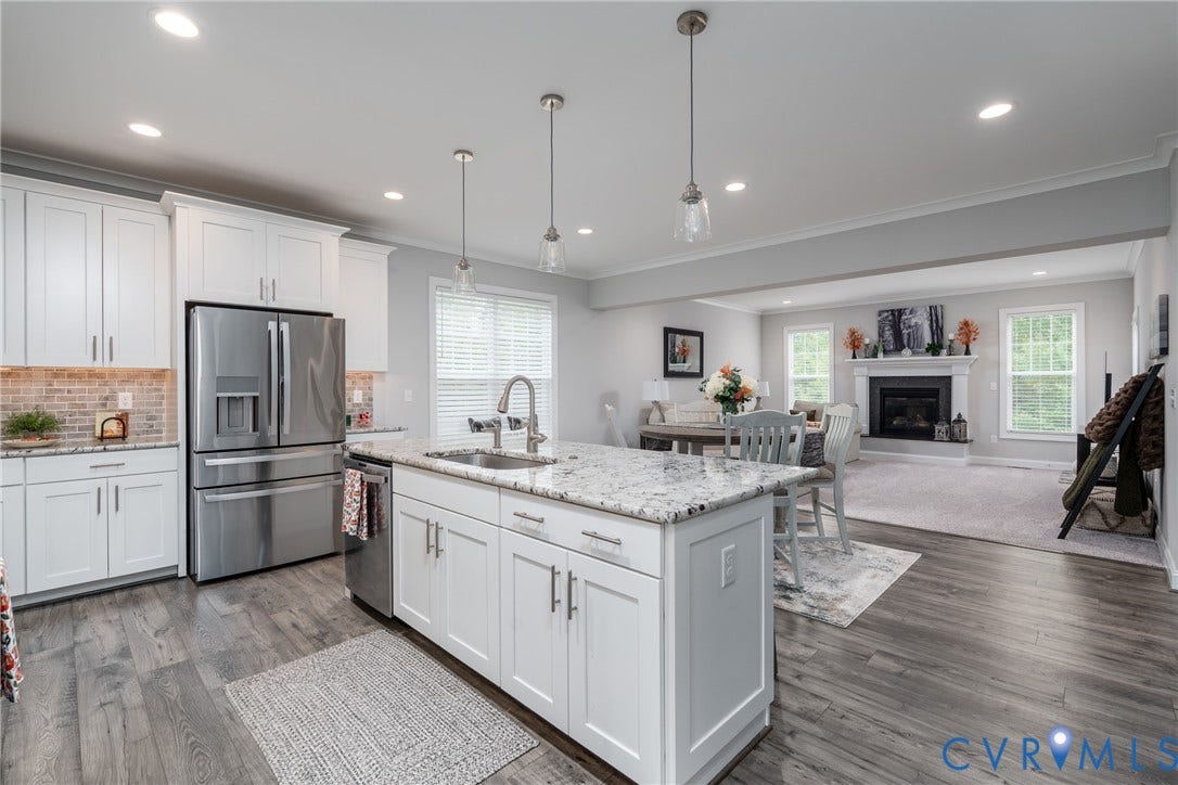 12303 Beech Hall Circle, Manakin Sabot, VA 23103 Expansive kitchen featuring wood-finish flooring, white cabinetry, a large kitchen island with counter seating, stainless steel appliances, and recessed lighting