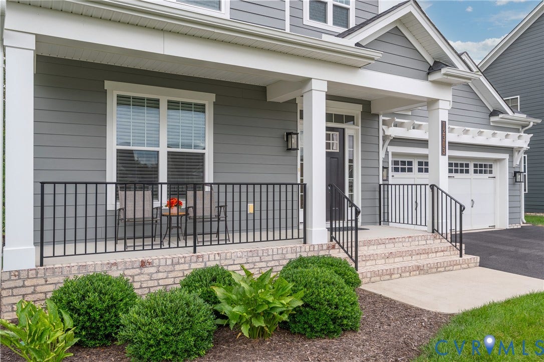 12303 Beech Hall Circle, Manakin Sabot, VA 23103 Front exterior featuring gray siding, white trim, a covered porch with black railings, a black front door, and an attached white garage door