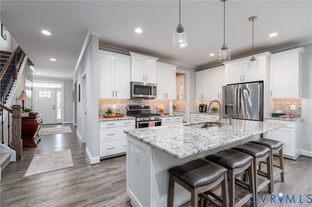 12303 Beech Hall Circle, Manakin Sabot, VA 23103 Kitchen featuring white cabinetry, stainless steel appliances, a multi-level island with a built-in sink, and pendant lighting