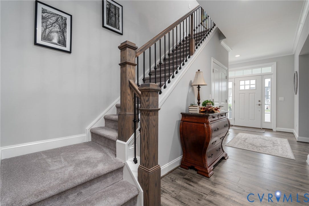 12303 Beech Hall Circle, Manakin Sabot, VA 23103 Wood-finish flooring, staircase with wood newel posts, black iron balusters, and carpeted treads, and a paneled entry door with sidelights and transom