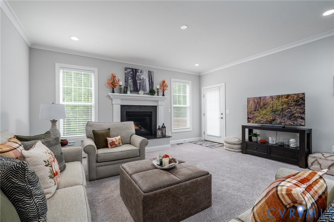 12303 Beech Hall Circle, Manakin Sabot, VA 23103 Spacious living area featuring light gray walls, recessed lighting, crown molding, a fireplace with a white mantel, and light gray carpeting
