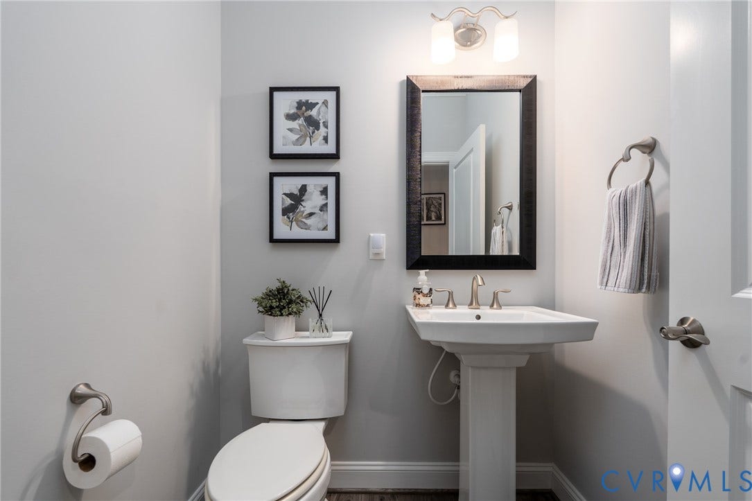12303 Beech Hall Circle, Manakin Sabot, VA 23103 Pedestal sink, brushed nickel plumbing fixtures, rectangular framed mirror, and two-light vanity fixture