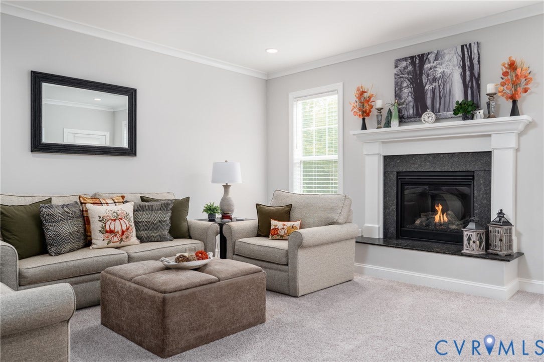 12303 Beech Hall Circle, Manakin Sabot, VA 23103 White crown molding, light gray wall color, white window trim, black stone fireplace surround, and a white mantel