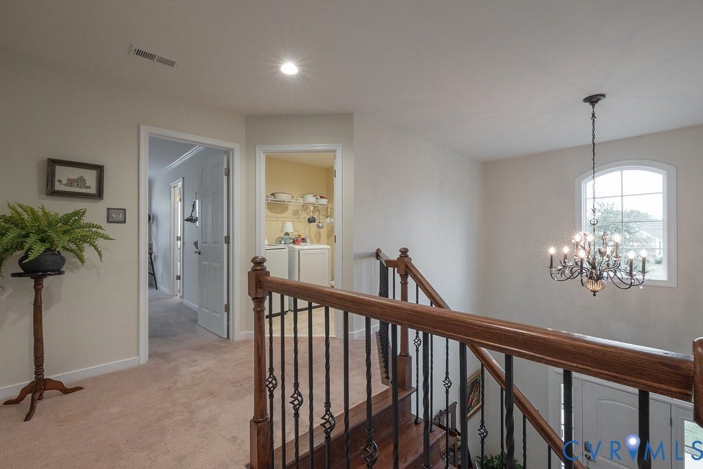 6301 Broad Sky Circle, Quiet, Mechanicsville, VA 23111 Wood-finish staircase with wrought iron balusters, arched window, and chandelier
