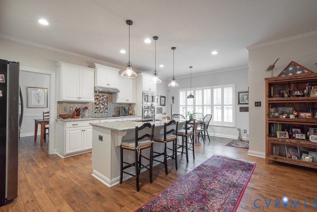 6301 Broad Sky Circle, Quiet, Mechanicsville, VA 23111 Kitchen featuring a central island with seating, pendant lighting, white cabinetry, integrated double ovens, and wood-finish flooring