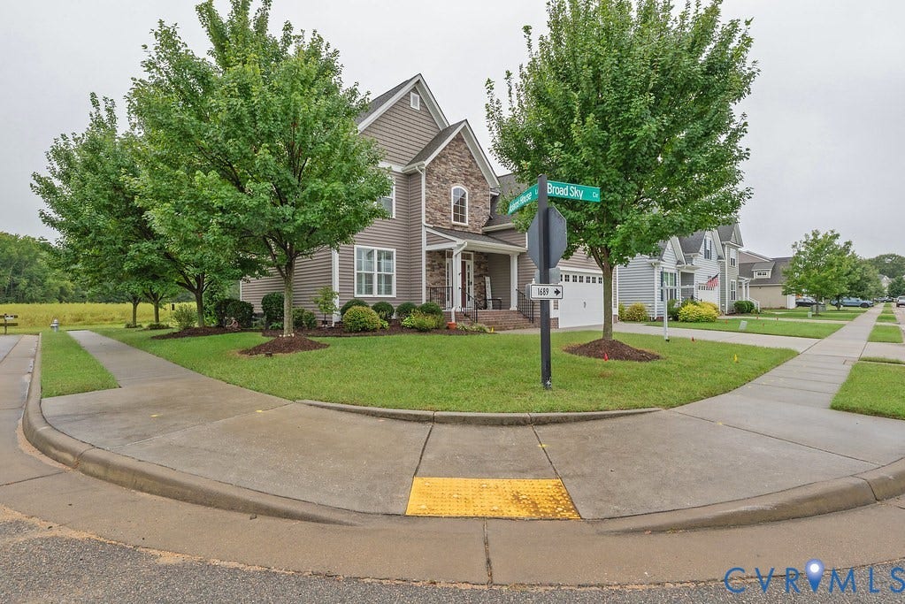 6301 Broad Sky Circle, Quiet, Mechanicsville, VA 23111 Two-story exterior with siding and stone accents, covered front porch, attached garage, and mature landscaping