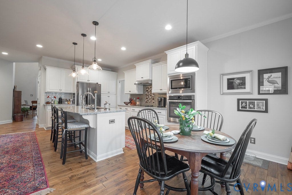 6301 Broad Sky Circle, Quiet, Mechanicsville, VA 23111 Gourmet kitchen with wood-finish flooring, white cabinetry, stainless steel appliances, a center island with bar seating, and recessed lighting