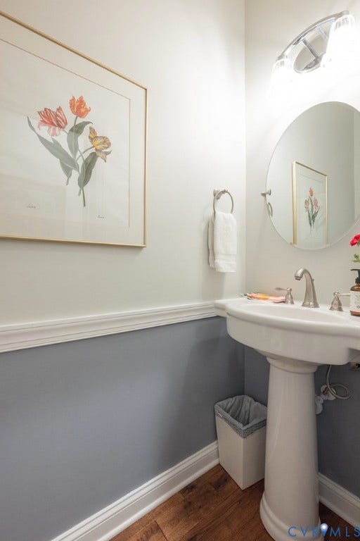 6301 Broad Sky Circle, Quiet, Mechanicsville, VA 23111 Pedestal sink with brushed nickel faucet, wall-mounted circular mirror, and wood-finish flooring