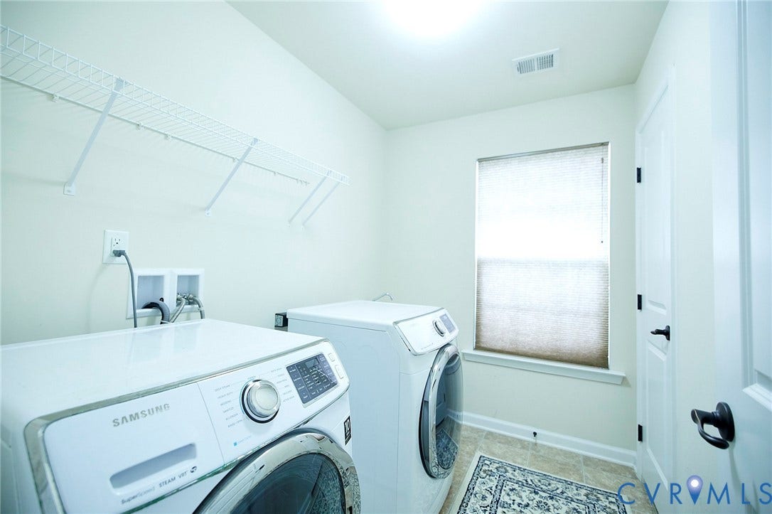 Utility room with light-toned walls, tile flooring, and a single window