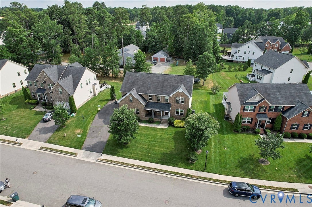 Brick and siding exterior, multi-car driveway, attached garage, gabled roofline, and front porch