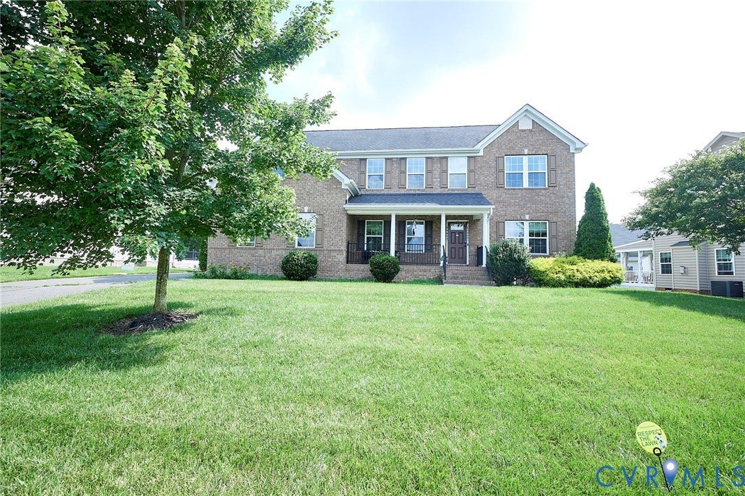 Brick exterior with a covered front porch and mature landscaping
