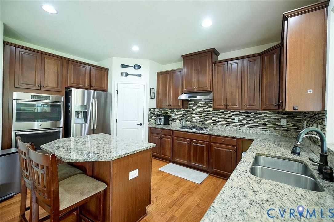 Kitchen featuring wood-finish flooring, recessed lighting, and a dual basin sink