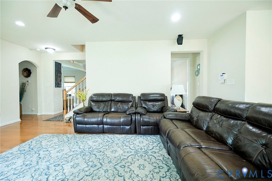 Recessed ceiling lighting, wood-finish flooring, ceiling fan, and an arched entryway