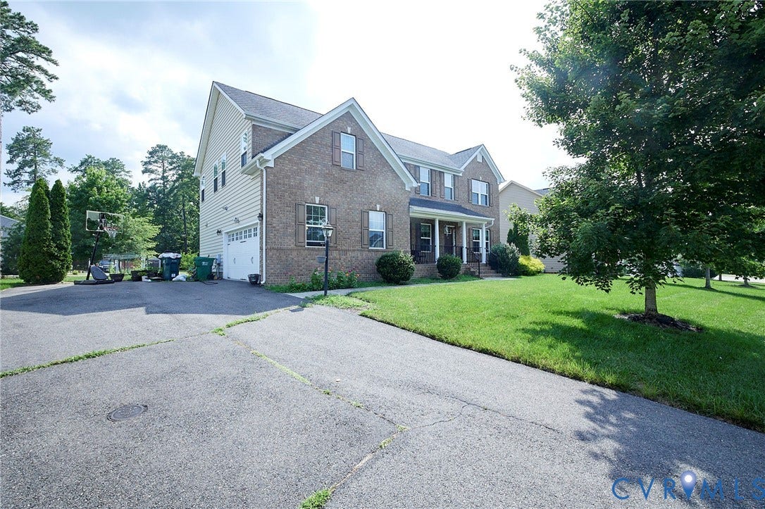 Brick and siding exterior with a covered front porch and a two-car garage