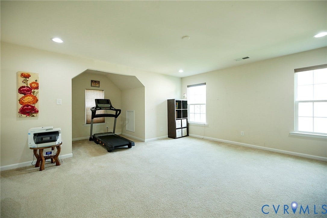Spacious room with recessed lighting, two windows, and light-colored carpeting