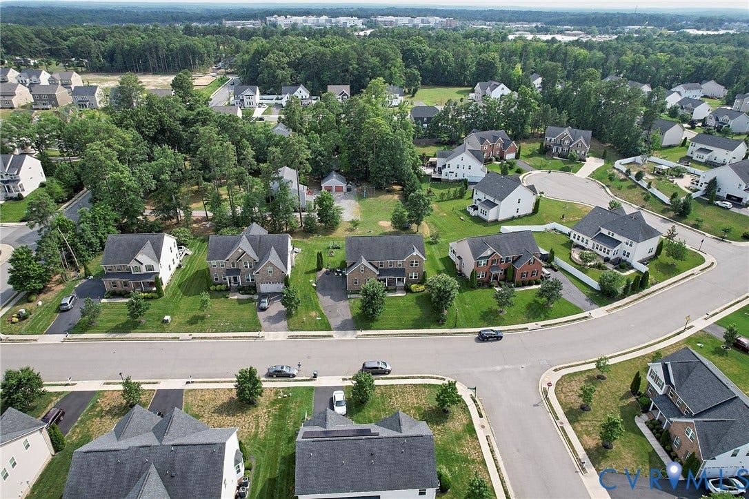 Residential streetscape with tree-lined surroundings and paved roadways