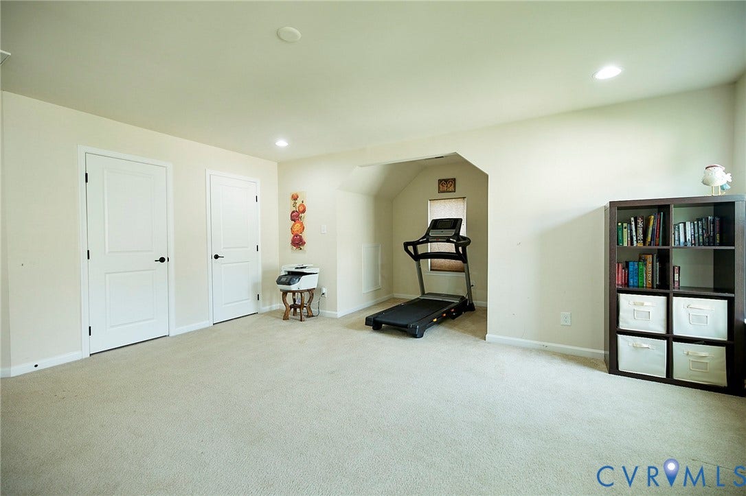 Recessed lighting, two paneled interior doors with black hardware, and an architectural alcove