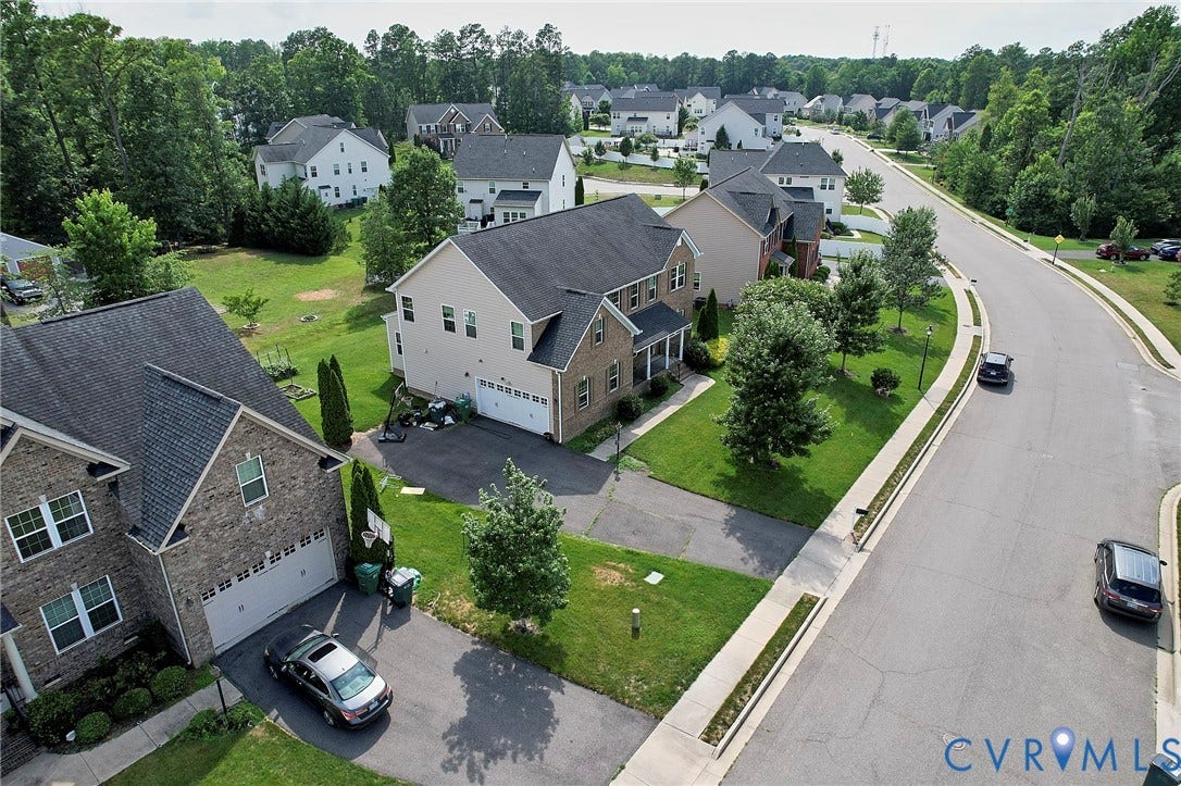 Residential streetscape featuring a paved road, sidewalks, and street lighting