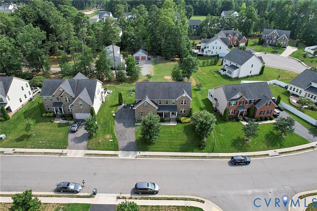 Two-story property featuring a brick and siding exterior, front-facing garage, and a paved driveway